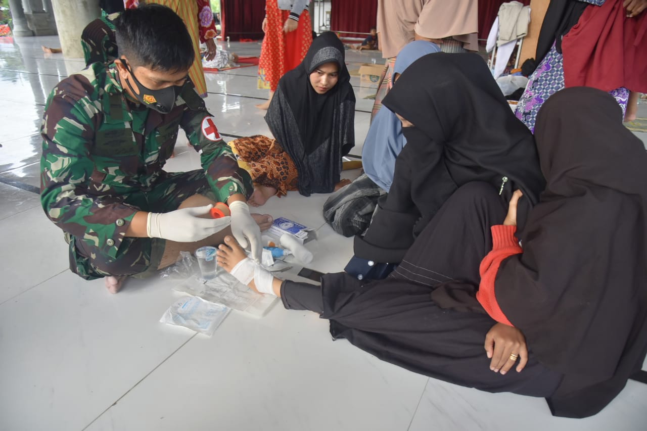 TNI Angkatan Laut sedang memberikan penangan medis terhadap korban banjir di Aceh Utara. Riskita