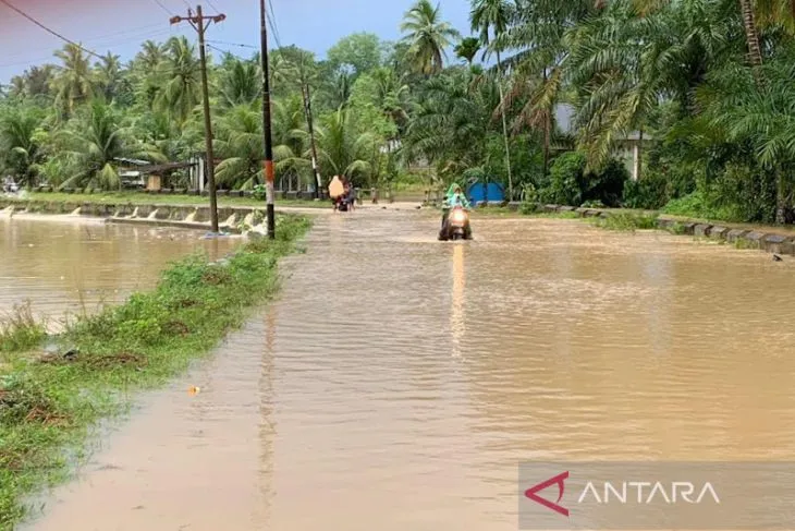 Pengendara sepeda motor melintasi jalan terendam banjir di Desa Rayeuk Kareung, Kecamatan Blang Mangat, Kota Lhokseumawe, Rabu (21/12/2022). (ANTARA/Dedy Syahputra)